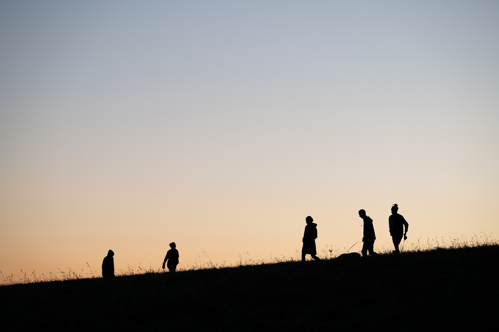 Silohettes on hill during sunset